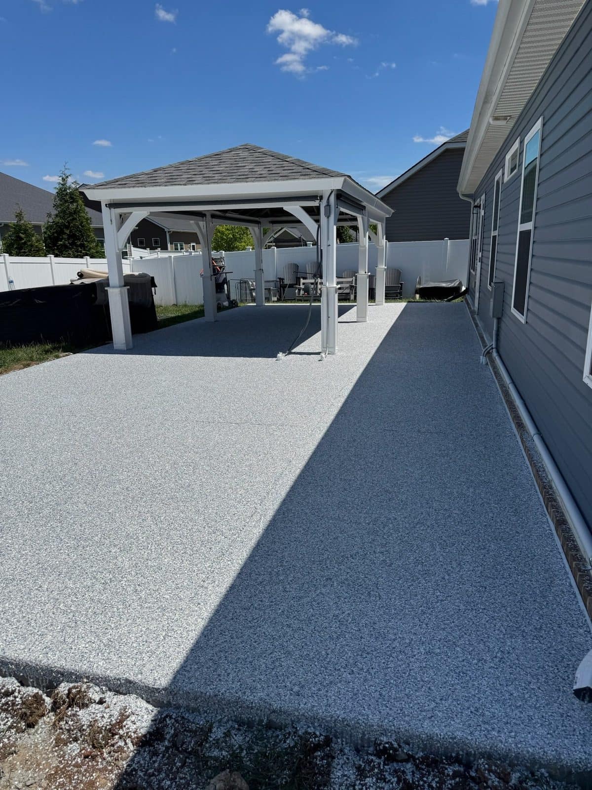 Coated back patio along the house, pergola behind